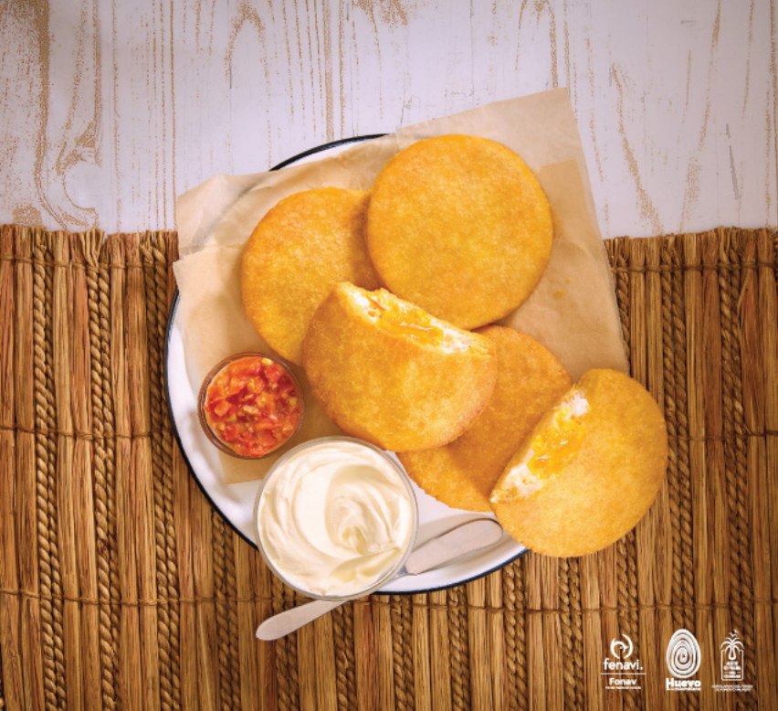 Arepas de huevo doradas con hogao y suero costeño